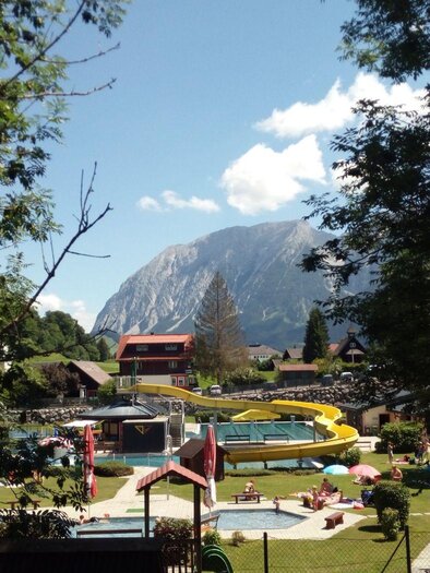 A beautiful landscape with a swimming pool and a slide. In the background, there are mountains and a clear sky. | © Johanna Provatopoulos
