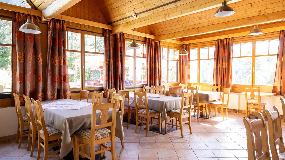 Ein helles Restaurant mit Holzwänden und großen Fenstern. Es gibt mehrere Tische mit Stühlen und eine einladende Atmosphäre. | © TV Region Graz-Harry Schiffe