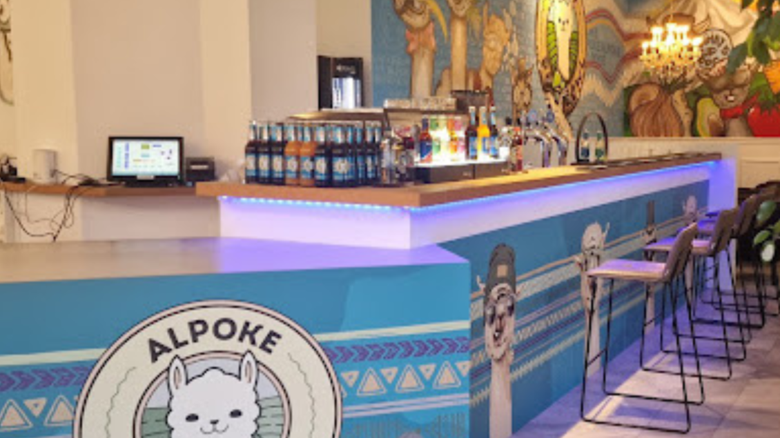 Ein modernes Restaurant mit einer bunten Wandmalerei und einer Theke, die Poke Bowls anbietet. Die Einrichtung ist einladend und freundlich, mit einer Kombination aus Stühlen und Tischen. | © Alpoke - K.von Kerken