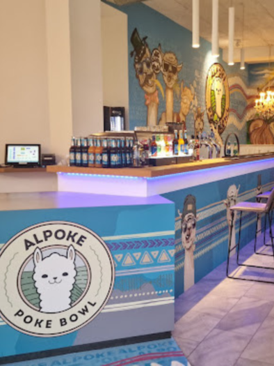 Ein modernes Restaurant mit einer bunten Wandmalerei und einer Theke, die Poke Bowls anbietet. Die Einrichtung ist einladend und freundlich, mit einer Kombination aus Stühlen und Tischen. | © Alpoke - K.von Kerken