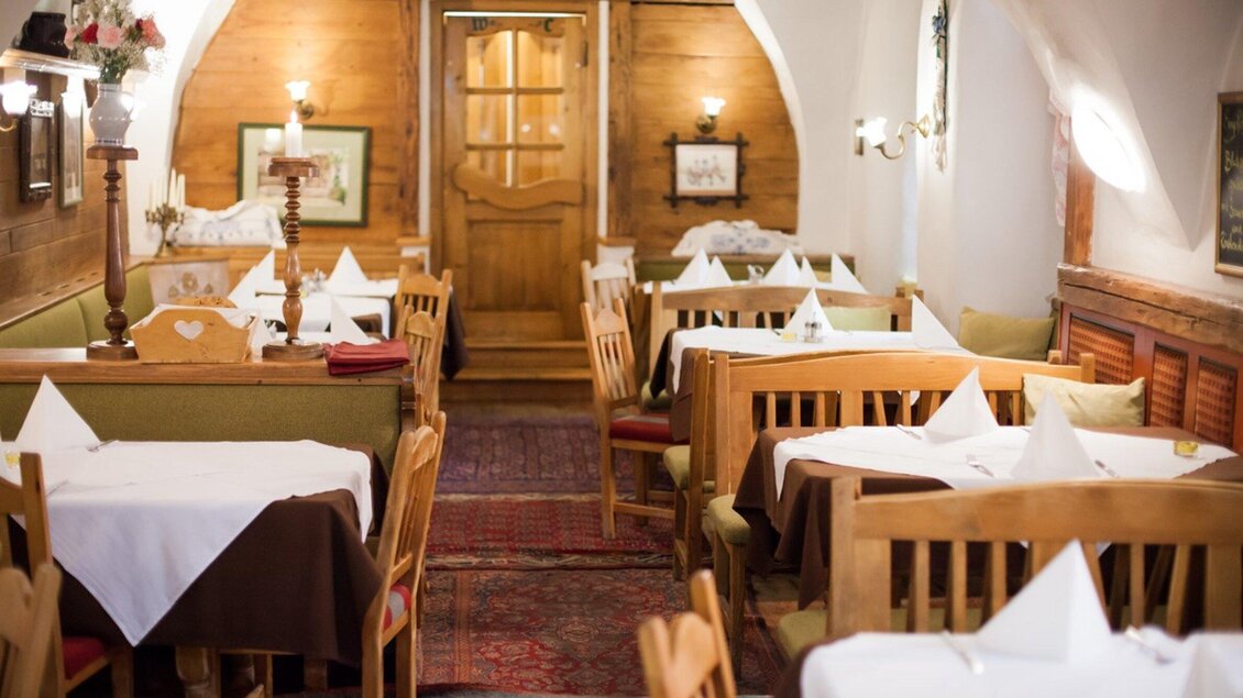 Ein gemütliches Restaurant mit Holzmöbeln und festlich eindeckten Tischen. Die warmen Farben und die einladende Atmosphäre schaffen eine angenehme Stimmung. | © Altsteirische Schmankerlstube