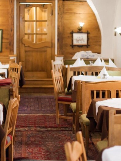 Ein gemütliches Restaurant mit Holzmöbeln und festlich eindeckten Tischen. Die warmen Farben und die einladende Atmosphäre schaffen eine angenehme Stimmung. | © Altsteirische Schmankerlstube