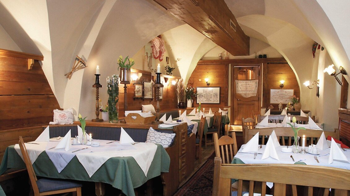 Ein gemütliches Restaurant mit Holzdekor und eleganten Tischgedecken. Die Atmosphäre ist warm und einladend. | © Altsteirische Schmankerlstube