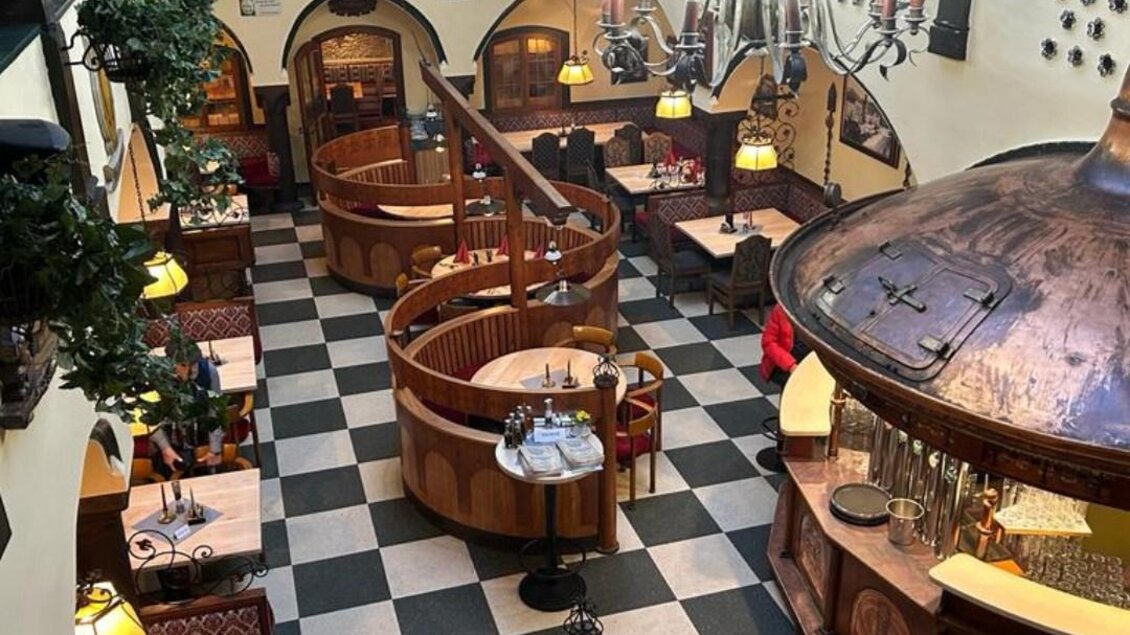 Ein gemütliches Restaurant mit rustikalem Design und vielen Holzelementen. Die runden Nischen sind gut beleuchtet und schaffen eine einladende Atmosphäre. | © Arkadenhof