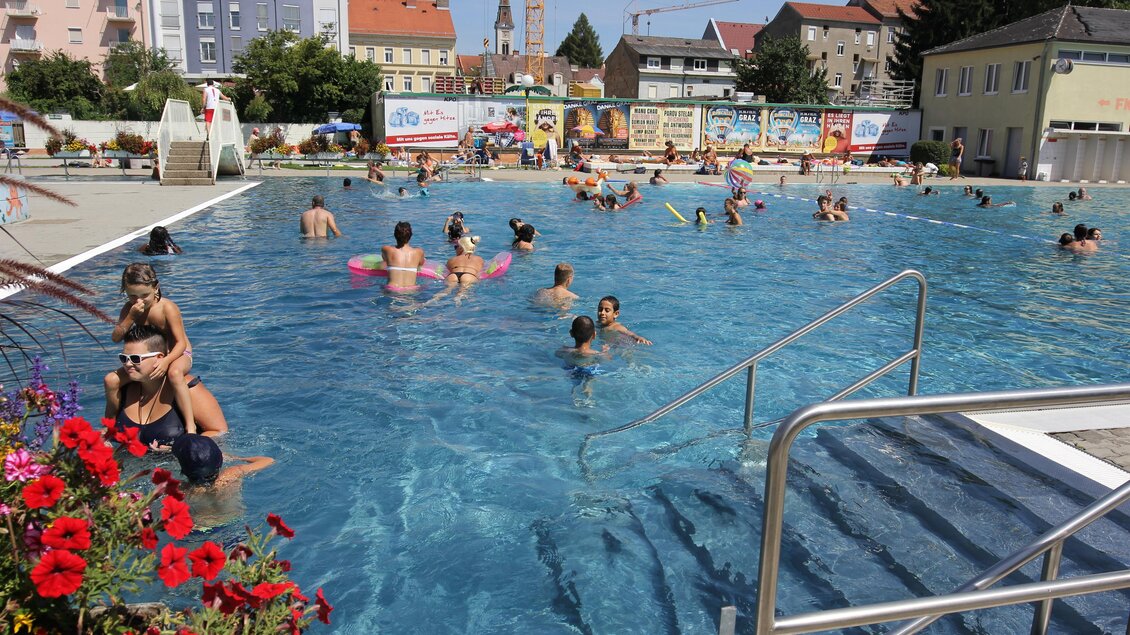 Menschen genießen das Schwimmen im Augartenbad Graz an einem sonnigen Sommertag | © Holding Graz-Wiliam Holzer