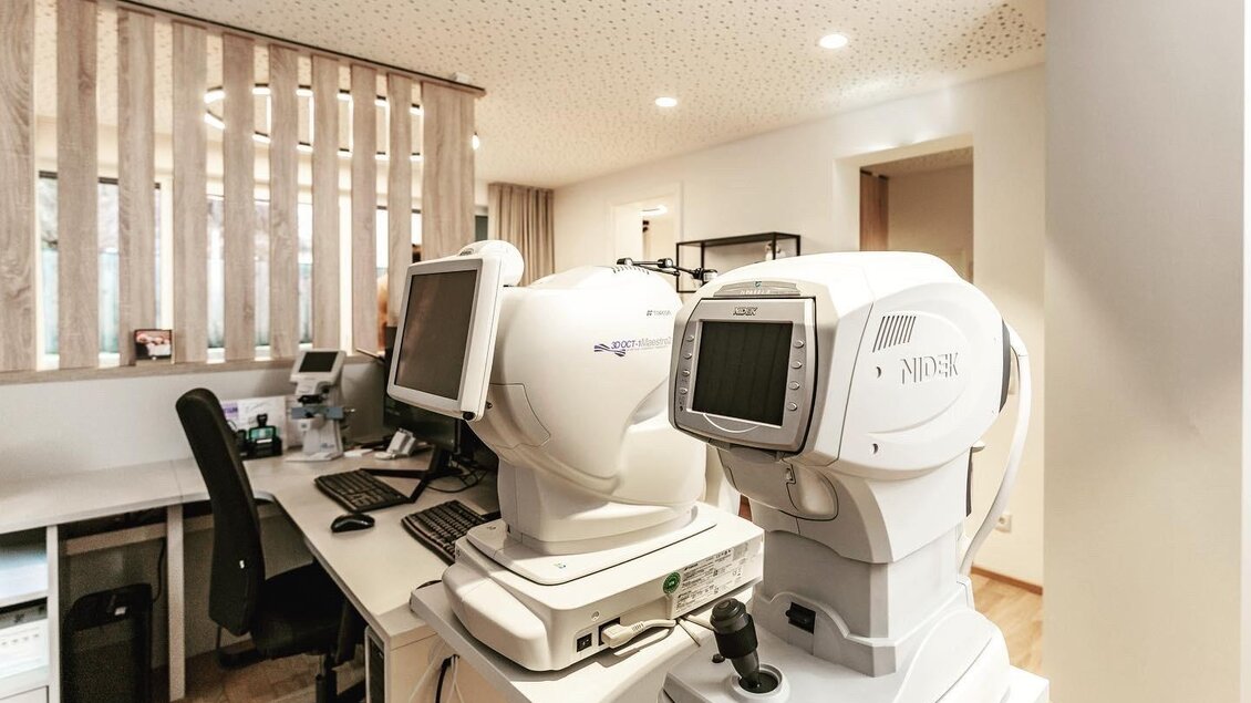 Eine moderne Augenklinik mit medizinischen Geräten und einem aufgeräumten Arbeitsbereich. Der Raum ist hell und freundlich gestaltet.