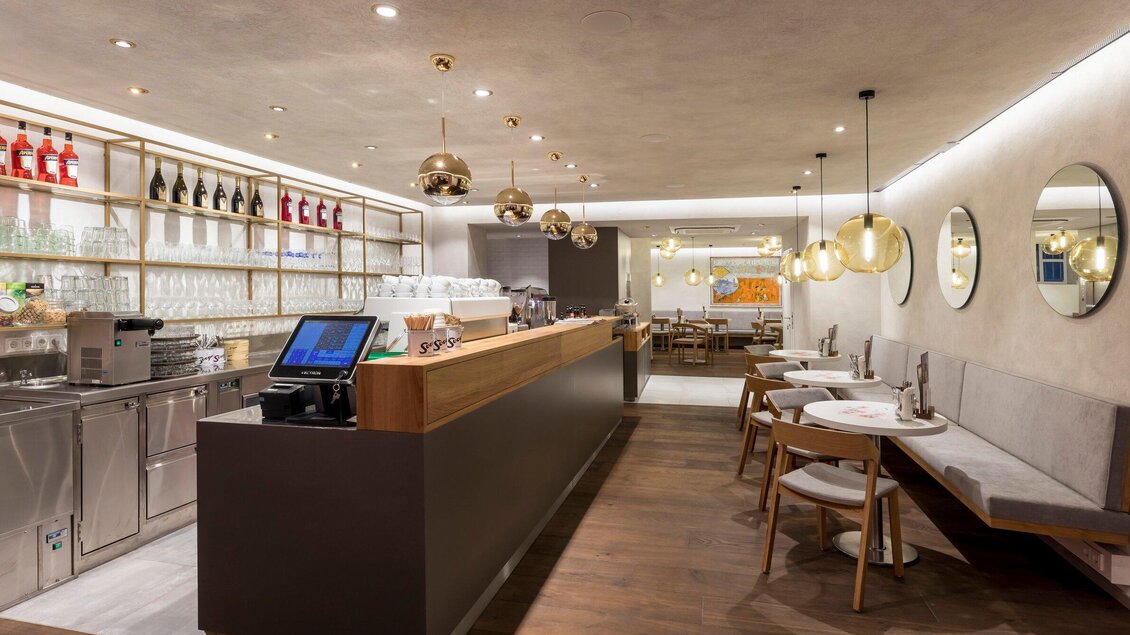 Ein modernes Restaurant mit einer eleganten Bar und gemütlichen Sitzbereichen. Die Beleuchtung ist warm und schafft eine einladende Atmosphäre. | © Sorger - Werner Krug