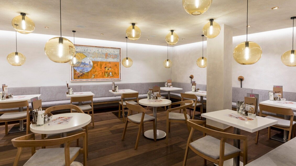 Ein modernes Restaurant mit eleganten Tischen und Stühlen. Die warmen Lichter schaffen eine einladende Atmosphäre. | © Sorger - Werner Krug