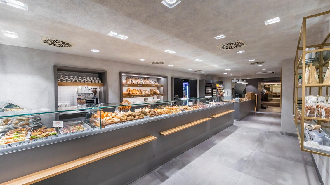 Eine moderne Bäckerei mit einem ansprechend gestalteten Verkaufsbereich. Im Auslagefenster sind verschiedene Backwaren und Snacks sichtbar. | © Sorger - Werner Krug