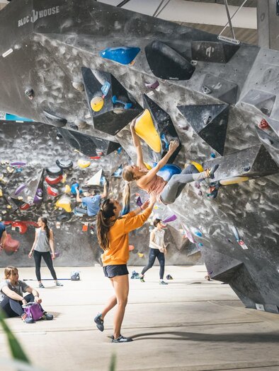 Menschen beim Bouldern an künstlichen Kletterwänden im BLOC HOUSE Graz 