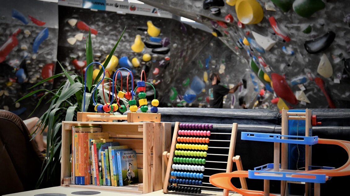 Spielzeug und Bücher in der Kinderecke einer Boulderhalle im BLOC HOUSE Graz | © BLOC house Graz
