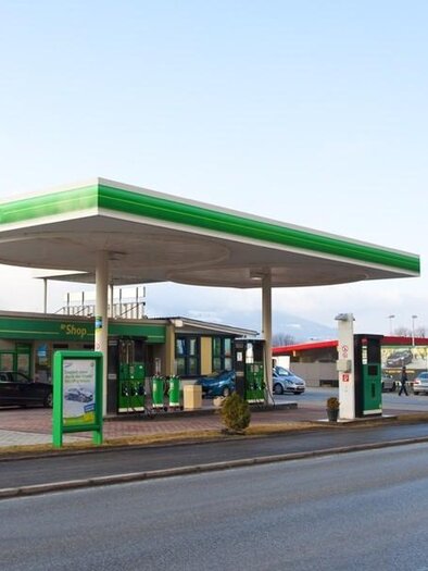 Eine Tankstelle mit grünem Logo und einem modernen Gebäude. Es gibt mehrere Zapfsäulen und geparkte Autos auf dem Gelände. | © BP Tankstelle Stainach