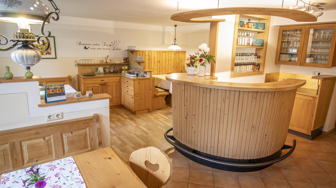 Eine gemütliche Küche mit Holzregalen und einer einladenden Theke. Der Raum hat warme Farben und bietet eine angenehme Atmosphäre. | © Famile Brandl