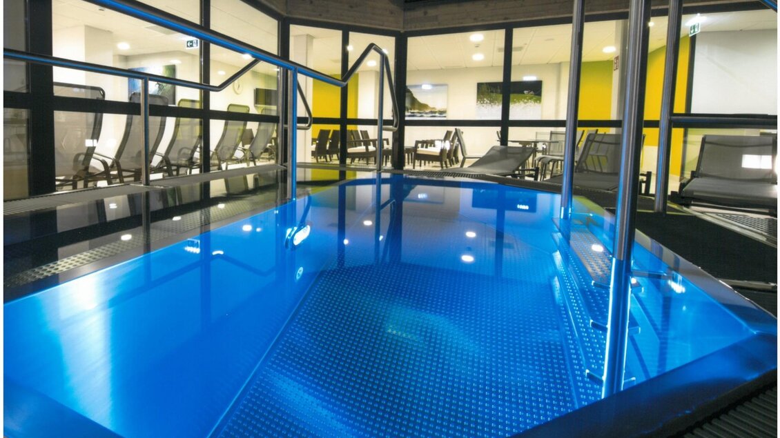 Ein moderner Innenpool mit klarblauem Wasser und einem minimalistischem Design. Im Hintergrund sind bequeme Liegen und ein heller Raum zu sehen. | © Stadtgemeinde Kapfenberg