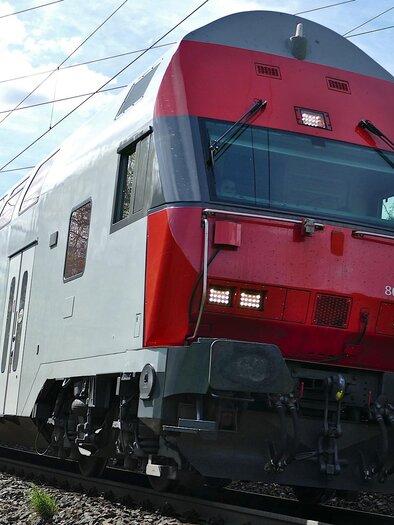 A modern train travels on a picturesque route. Surrounded by green meadows and a clear sky. | © Symbolfoto