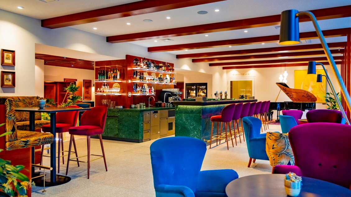  Farbige Sessel, lange Bar und Flügel in stilvollem Hotelambiente. | © Parkhotel Graz