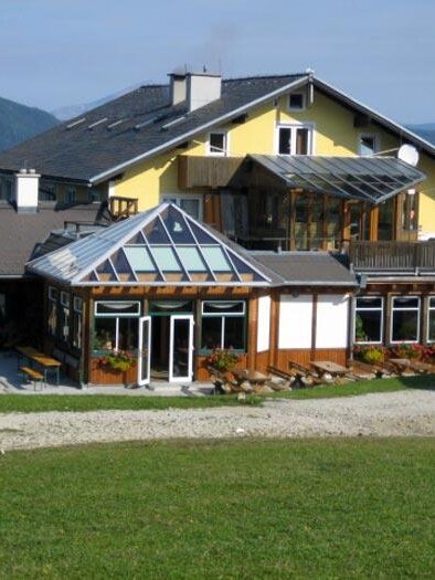 A charming building with a modern extension and large windows. It is situated in a picturesque mountain landscape. | © Fam. Filzwieser