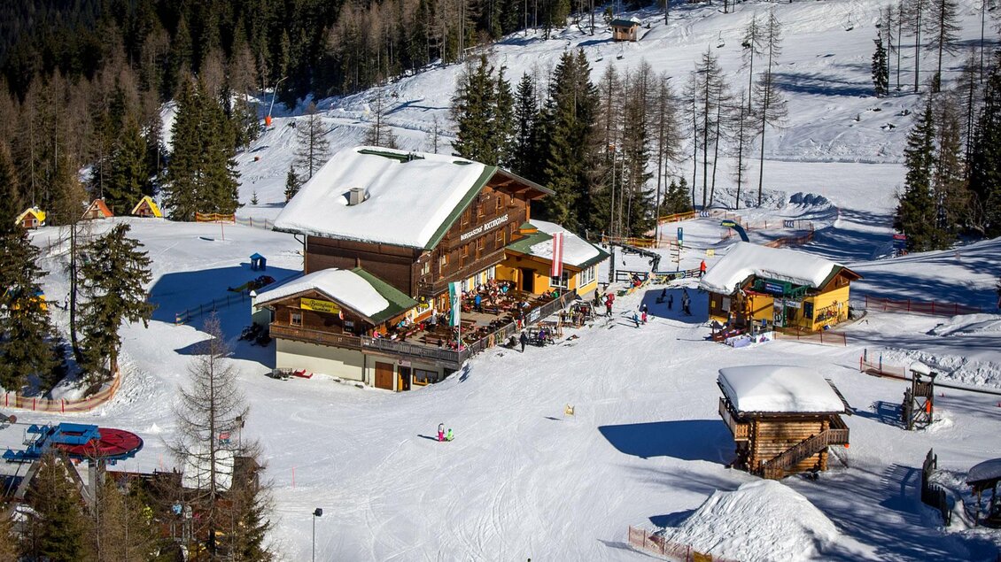 Eine malerische alpine Hütte im Schnee, umgeben von Tannenbäumen. Die Szenerie strahlt eine ruhige und einladende Winteratmosphäre aus. | © Berggasthof Bottinghaus