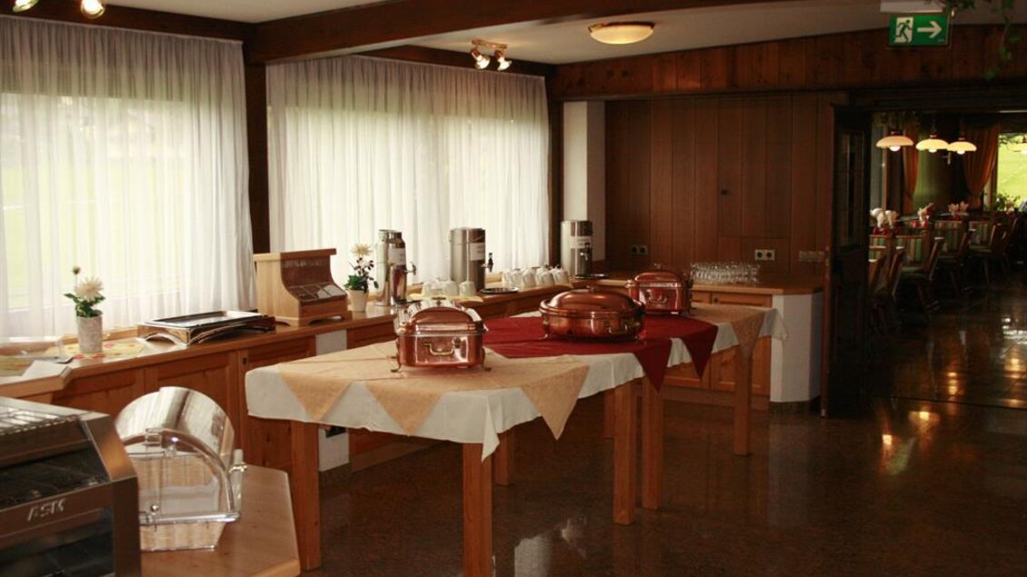 Ein gemütlicher Innenraum mit einem Buffet und verschiedenen Geräten zum Frühstück. Die Holzdekoration und das natürliche Licht schaffen eine einladende Atmosphäre. | © Berghof Mitterberg