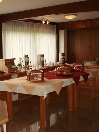 A cozy interior with a buffet and various appliances for breakfast. The wooden decoration and natural light create an inviting atmosphere. | © Berghof Mitterberg