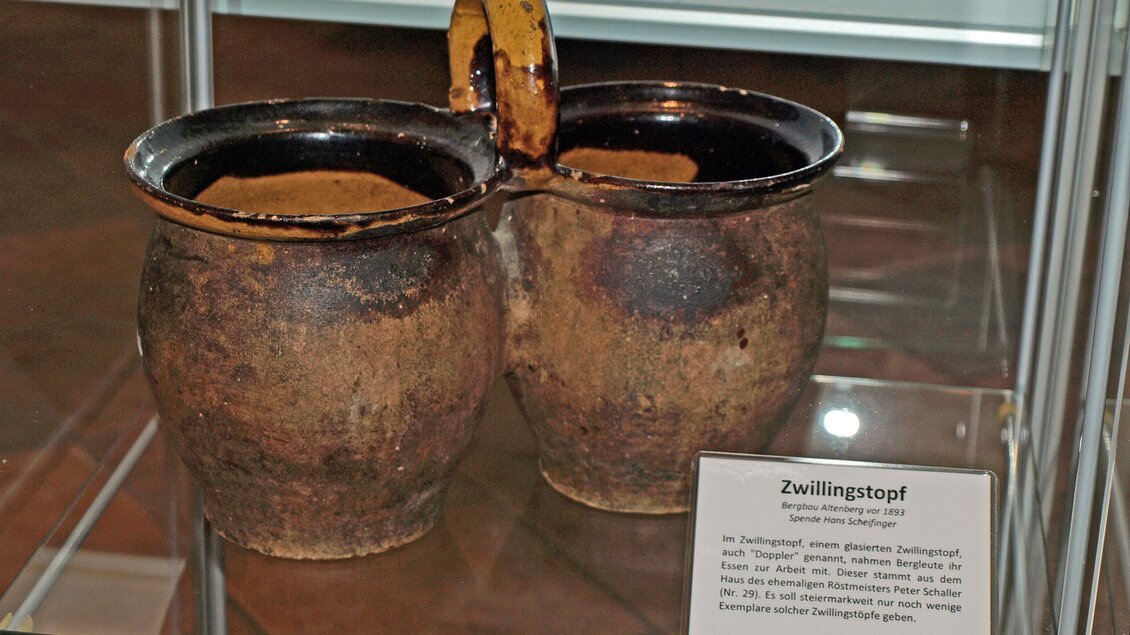 Ein Zwillingsstopf aus Erde mit zwei verbundenen Gefäßen. Die Töpfe sind rustikal und zeigen eine antike Handwerkskunst.