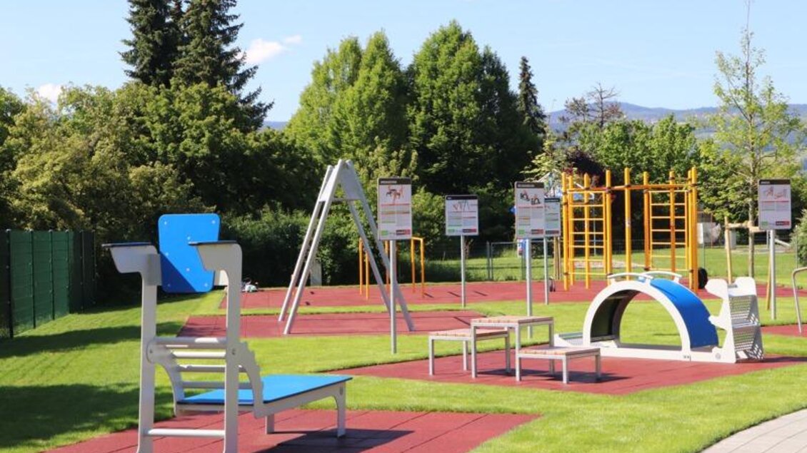 Ein moderner Außen-Spielplatz mit verschiedenen Sportgeräten. Die Fläche ist mit Rasen und Gummiboden ausgestattet, um Sicherheit zu gewährleisten. | © Robert Cescutti