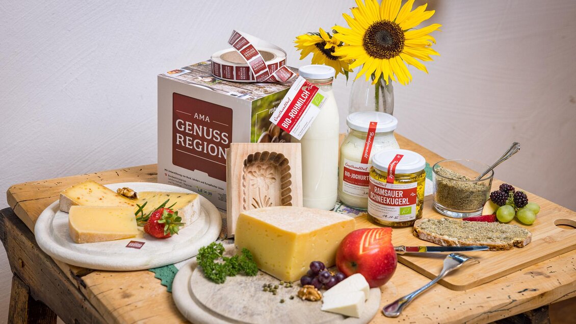 Ein schöner Tisch mit verschiedenen Käsesorten, frischem Obst und Gemüse. Im Hintergrund stehen Milchprodukte und eine Sonnenblume. | © Netzwerk Kulinarik wildbild