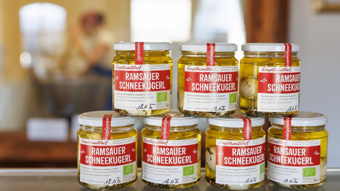 Sechs Gläser mit Ramsauer Schneekugeln stehen auf einem Tisch. Die Gläser sind mit roten Etiketten versehen und verleihen dem Bild eine ansprechende Präsentation. | © Martin Huber