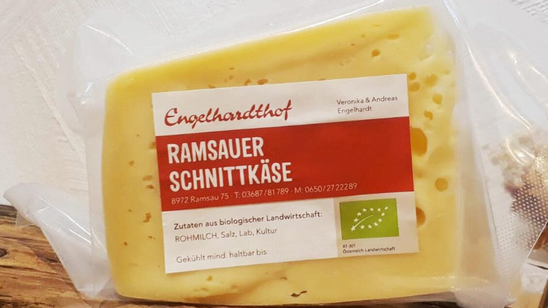 Ein Stück Ramsauer Schnittkäse verpackt in transparenter Folie. Der Käse hat eine hellgelbe Farbe und zeigt kleine Löcher. | © Engelhardthof