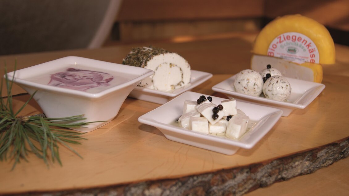 Eine Auswahl an verschiedenen Käsesorten auf weißen Tellern. Darunter sind frische Kräuterkäse und ein Stück Gouda zu sehen. | © Tourismusverband Murau