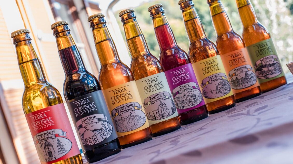 Eine Reihe von Flaschen mit verschiedenen Getränken auf einem Tisch. Die Flaschen haben bunte Etiketten und zeigen unterschiedliche Geschmacksrichtungen. | © Manuel Flor