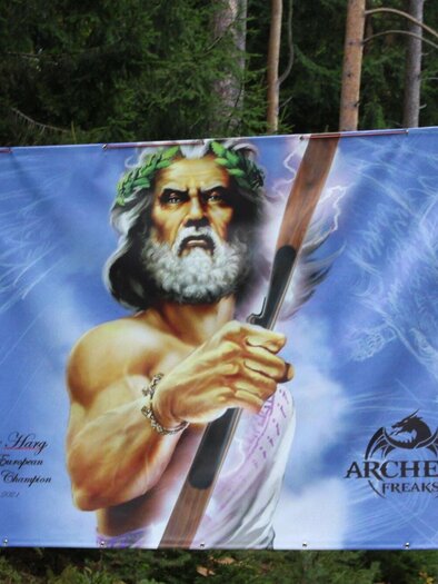 A large banner shows a mythical figure holding a bow. The depiction is surrounded by green trees in the background. | © Archery Freaks - Frahs