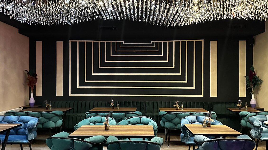 Ein stilvolles Restaurant mit modernem Design und gemütlichen Sitzplätzen. Die Wände sind mit geometrischen Mustern dekoriert und das Lichtunterschriften schafft eine einladende Atmosphäre. | © Bonbon