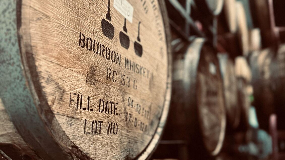 Ein Holzregal mit mehreren Bourbon-Fässern. Die Fässer sind sorgfältig gestapelt und weisen Etiketten mit Informationen auf. | © Brauhaus Bevog