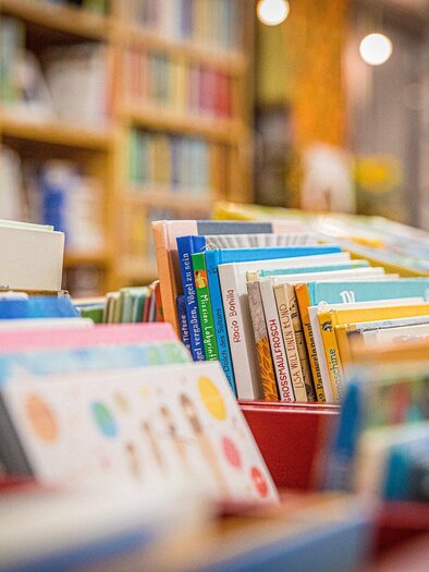 Colorful books on the shelves of a bookstore. In the background, more books are visible. | © Symbolfoto Pixabax