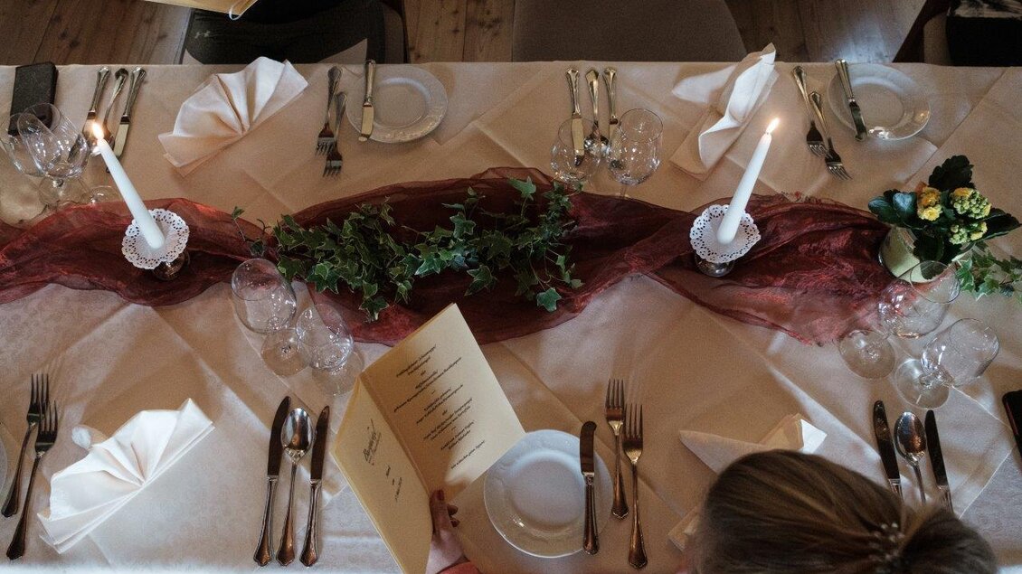 Ein festlich gedeckter Tisch mit eleganter Tischdeko. Viele Gläser, Besteck und Menükarten sind sorgfältig platziert. | © Schilcherland Steiermark