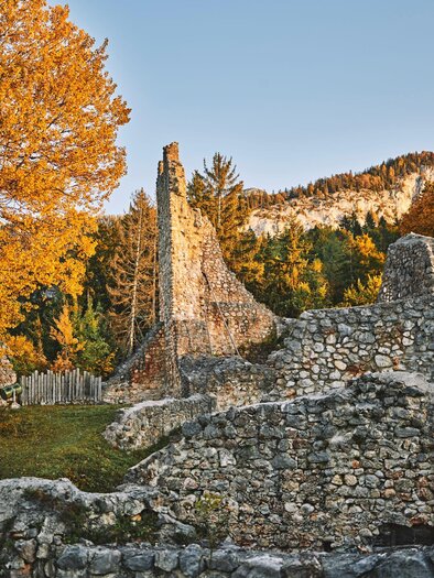 An old ruin surrounded by autumn trees. Nature displays warm colors and the landscape is picturesque. | © Armin Walcher