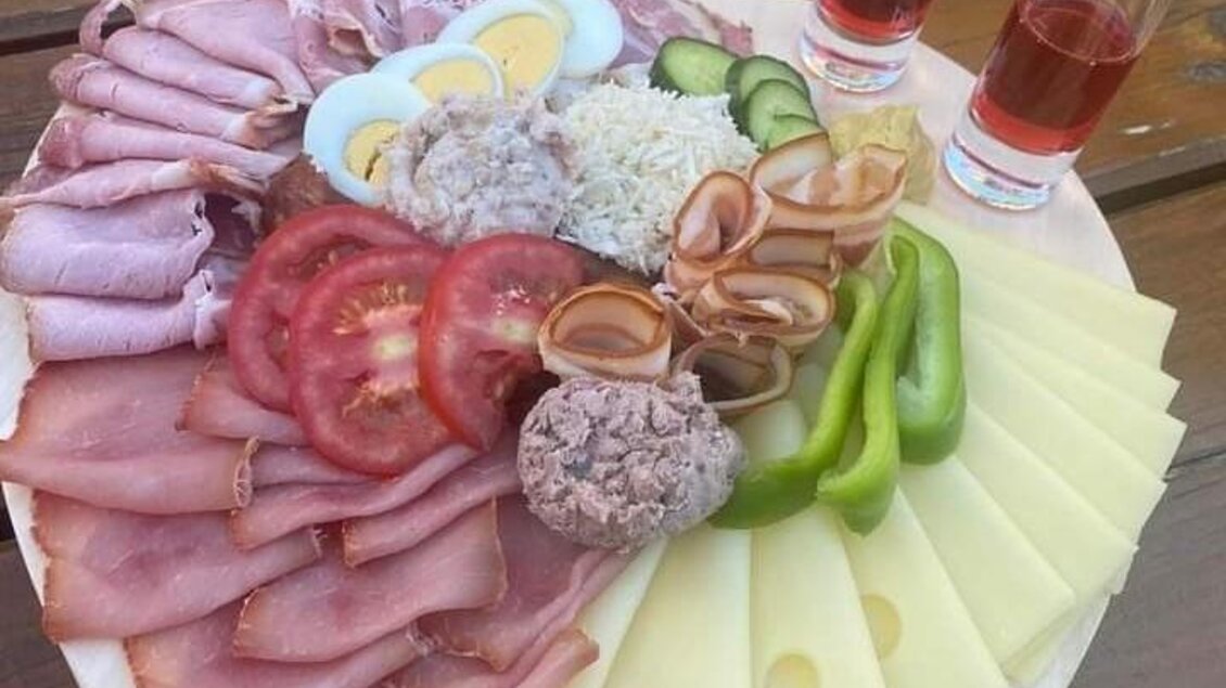 Eine bunte Platte mit Wurst, Käse, Eiern und frischem Gemüse. Dazu stehen zwei Gläser mit einem rosafarbenen Getränk. | © Fam. Tomaschitz