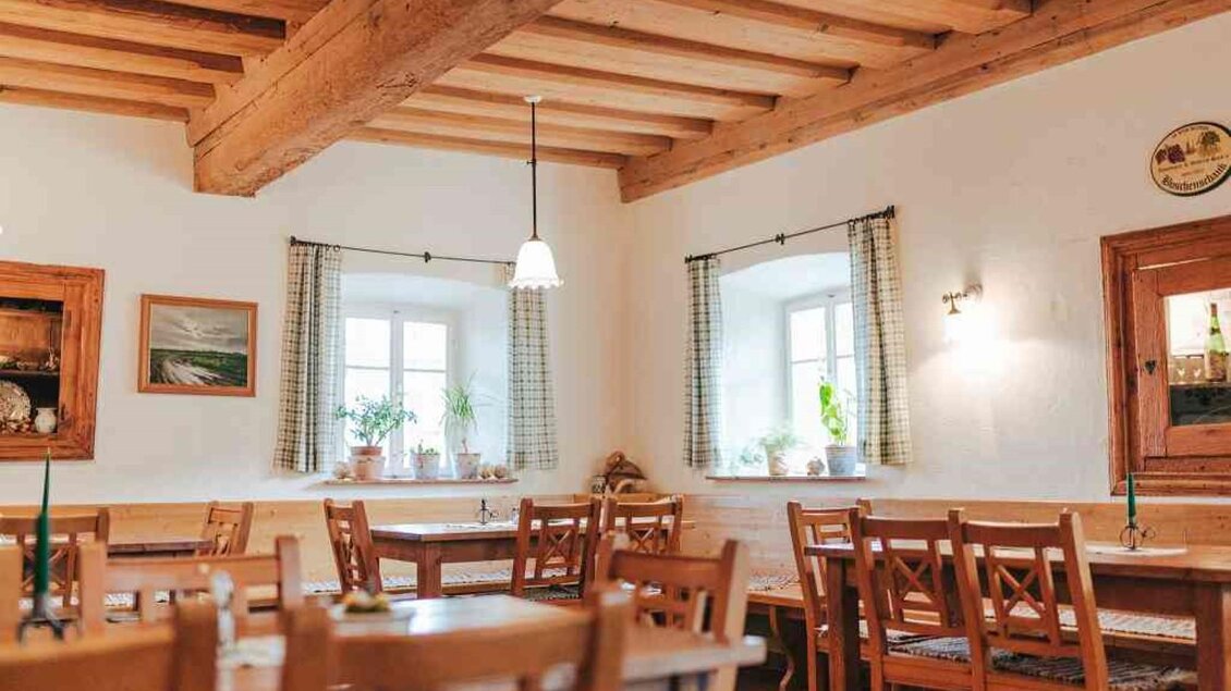 Ein gemütliches Restaurant mit Holzmöbeln und einem einladenden Ambiente. Große Fenster lassen viel Licht herein und es gibt Pflanzen auf den Fensterbänken. | © Hack-Gebell