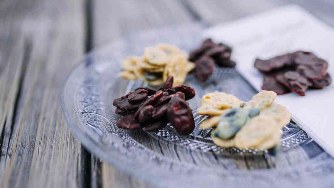 Eine Auswahl an verschiedenen Schokoladennüssen auf einem eleganten Teller. Die Nüsse sind in verschiedenen Farben und Formen angeordnet. | © Hack-Gebell