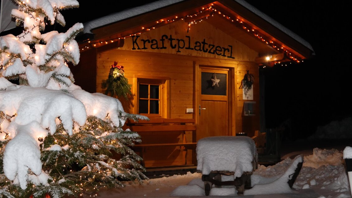 Ein gemütliches Holzhaus im Schnee, festlich beleuchtet mit Lichtern. Ein verschneiter Baum steht daneben, und die Szene strahlt eine winterliche Atmosphäre aus. | © Brigitte Maier | Klapotetzhof Silberschneider