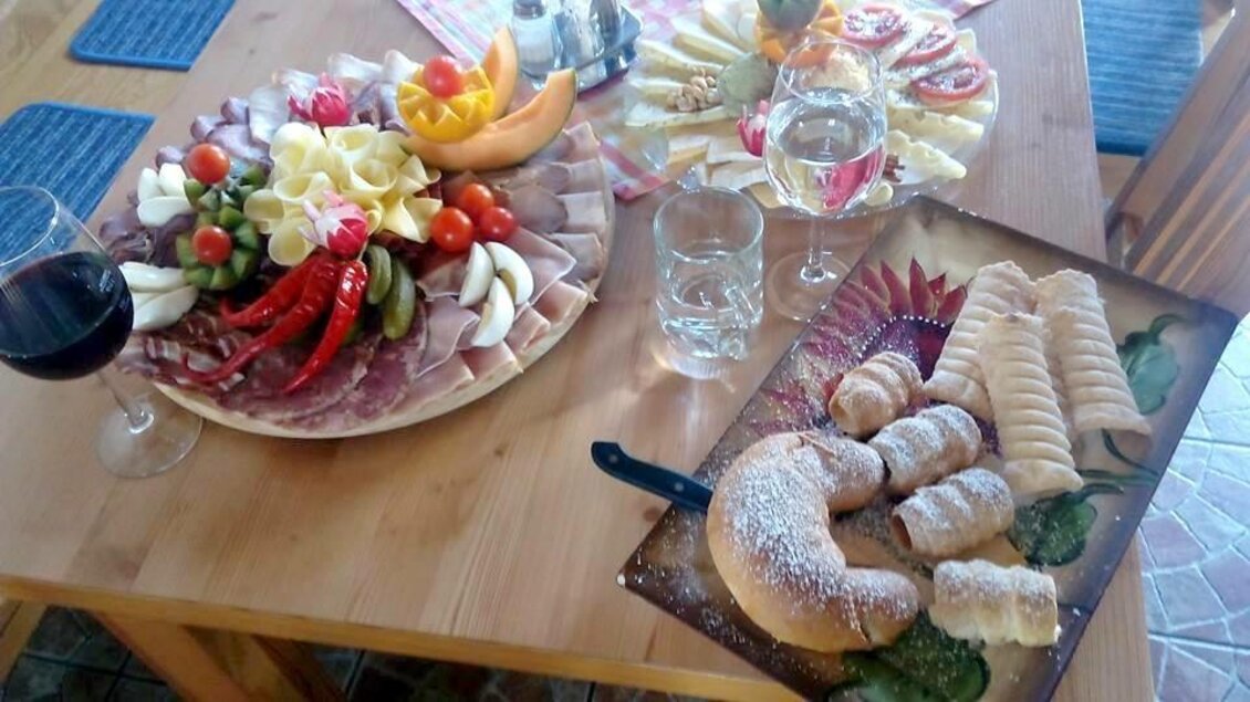 Ein gedeckter Tisch mit einer Auswahl an Wurst, Käse und frischem Obst. Dazu gibt es Wein, Wasser und köstliche Gebäcke. | © Familie Kober