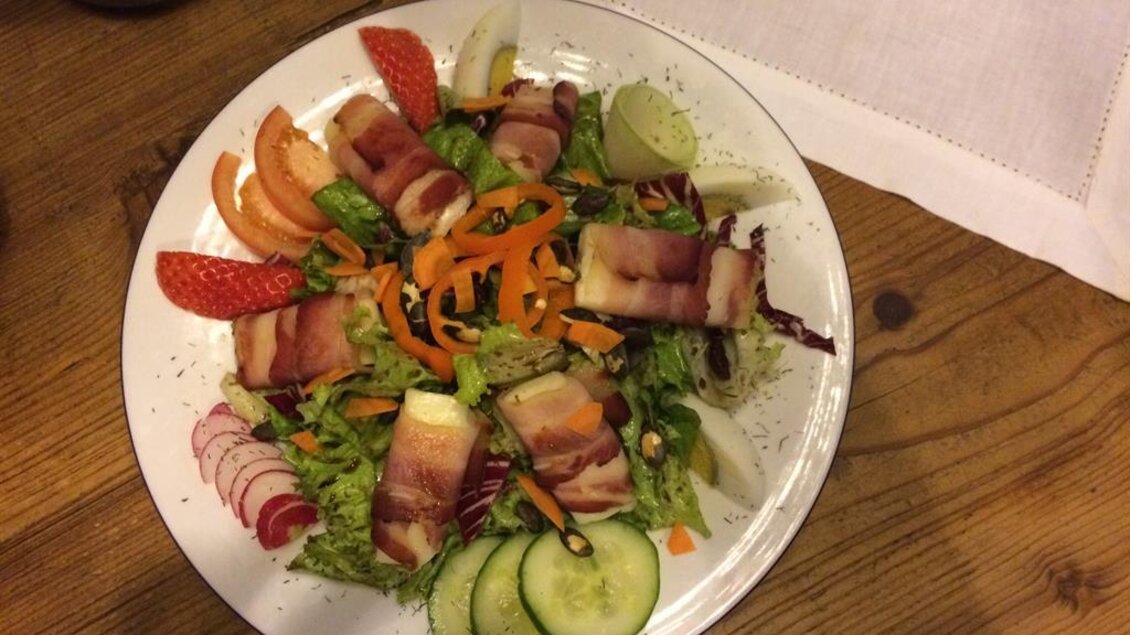Ein bunter Salat mit frischem Gemüse und Bacon-Wickeln. Dazu eine garnierte Mischung aus Erdbeeren und Orangenstücken. | © Buschenschank Musterstubn l Nina & Armin Polz-Kiefer