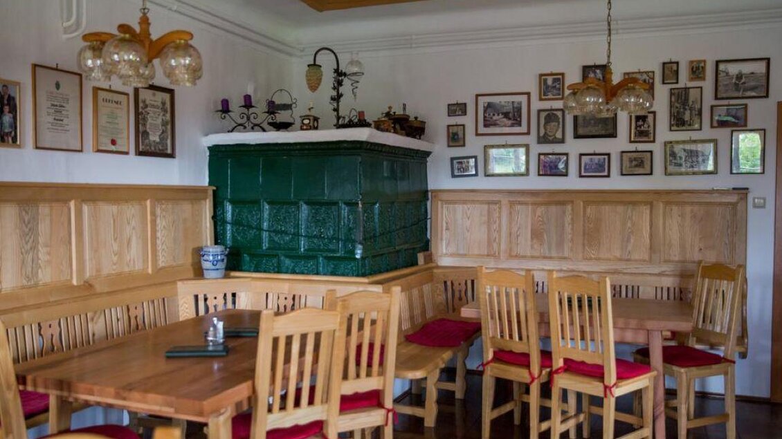Ein gemütliches Gasthaus mit Holzstühlen und Tischen. An den Wänden hängen viele Bilder und Erinnerungsstücke. | © Ofnerpeter