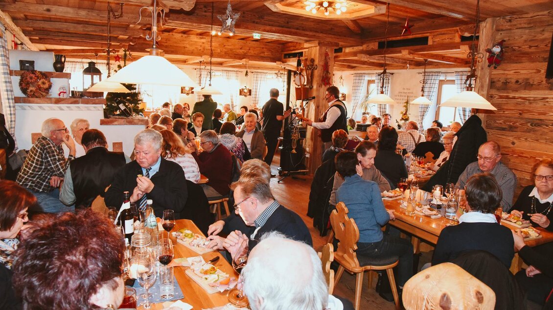 Ein belebtes Restaurant mit vielen Gästen, die an Tischen sitzen und essen. Die Atmosphäre ist gemütlich mit Holzdekor und warmem Licht. | © Thaler Wolfgang