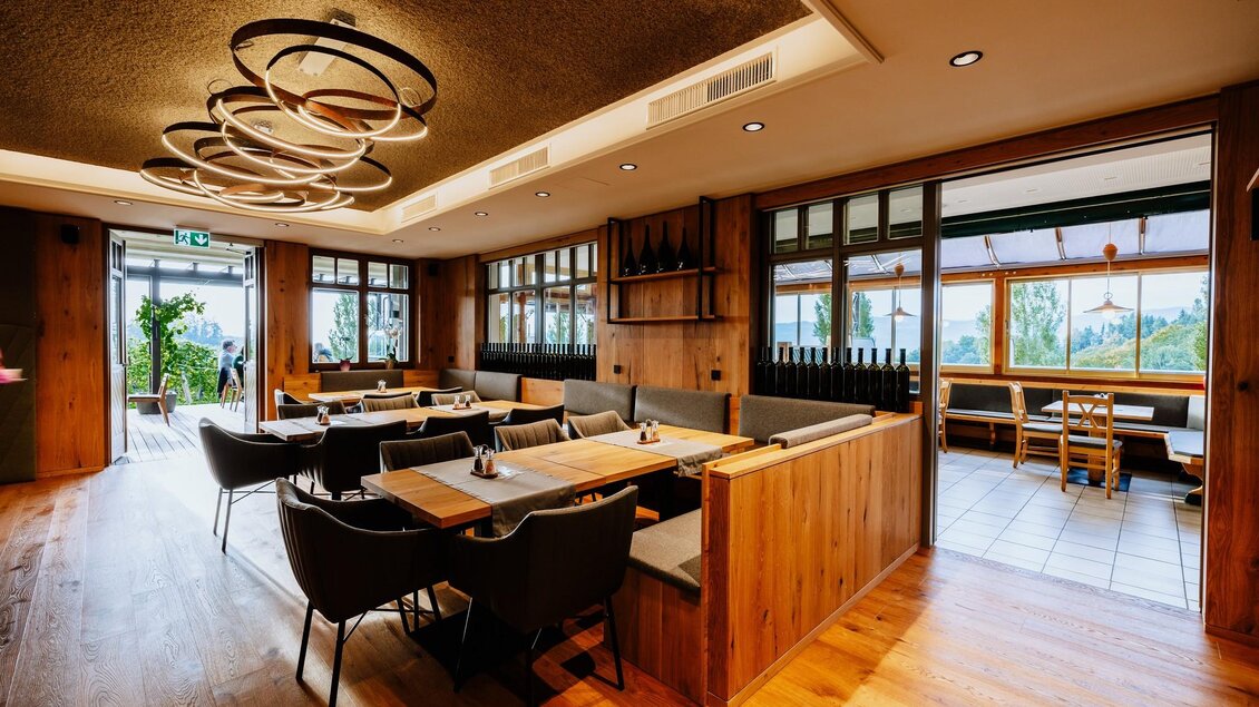 Ein modernes Restaurant mit Holzinterieur und bequemen Sitzplätzen. Große Fenster bieten einen schönen Blick nach draußen.