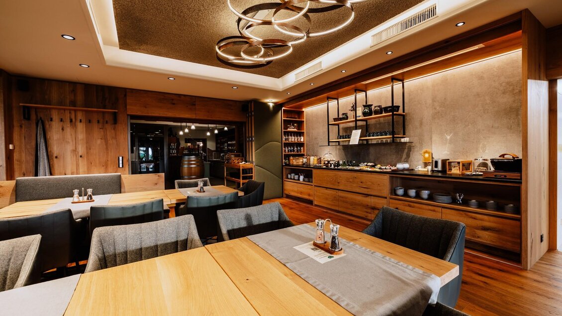 Ein modernes Restaurant mit Holzdecken und eleganten Möbeln. Die Atmosphäre ist warm und einladend.