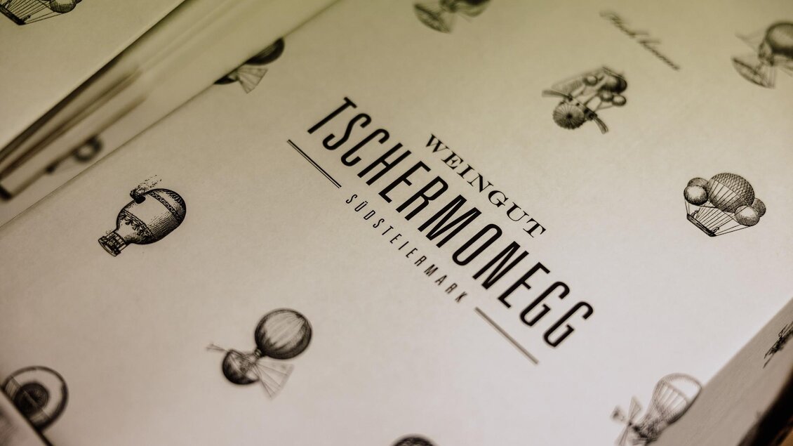 Eine stilvolle Weinkarte mit dem Namen "Weingut Tscherneweg" und Illustrationen von Heißluftballons. Die Gestaltung ist elegant und ansprechend.