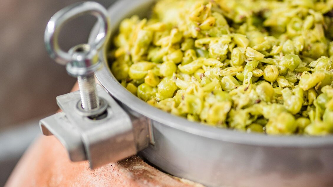 Ein großer Kochtopf mit frischen Kräutern oder Pflanzen. Der Topf steht auf einer speziellen Grundlage und hat eine Metallabdeckung. | © Weingut Tschermonegg