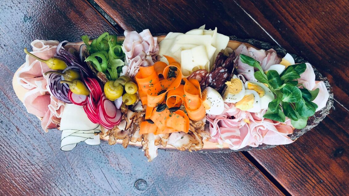 Eine attraktive Brettchen mit verschiedenen Aufschnittsorten, Käse und frischem Gemüse. Die Farben sind lebhaft und appetitlich. | © Weingut Weiss-Welle | Bettina Gratzer